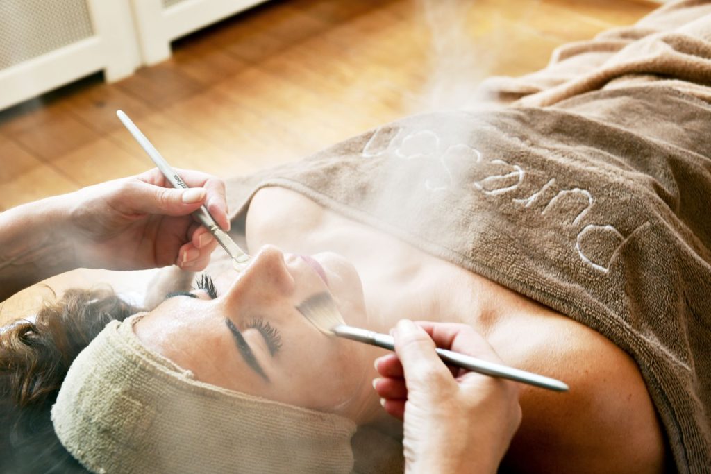 Gezichtsbehandeling met stoom en een kwast in de salon van PureSan in Den Haag